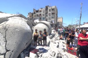 Palestinians perform Friday noon prayer next to the ruins of al-Farouq Mosque, destroyed during Israeli bombardment in Rafah in the southern Gaza Strip
