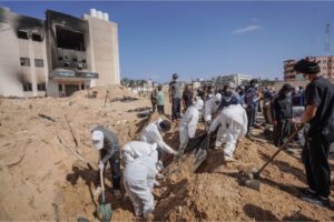 Palestinian health workers unearth a body buried by Israeli forces inside Nasser hospital compound in Khan Yunis in the southern Gaza Strip on April 21, 2024.