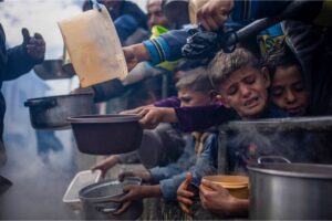 Children jostle to receive food in Rafah, Gaza