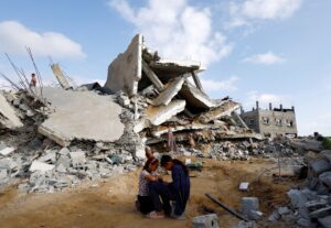 Palestinian children sit next to the site of an Israeli strike on a house in Rafah, in the southern Gaza Strip, April 21, 2024