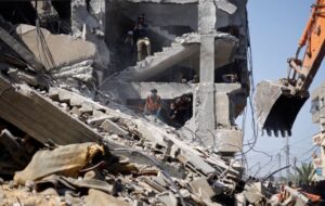 People inspect the site of an Israeli attack on a building in Rafah