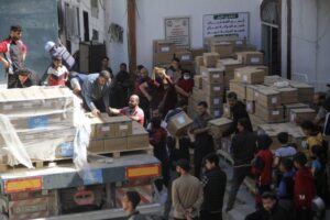 People unload medical aid from a truck near Kamal Adwan Hospital, Beit Lahiya. 