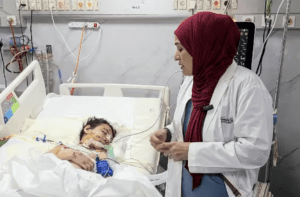 Dr Fozia Alvi checks in on a child who was shot in Gaza and is receiving care for brain and facial injuries at the European hospital near Rafah