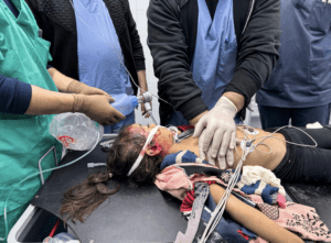 Medical staff perform CPR on a child who was shot in the head.