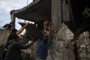 Palestinians rush to rescue injured people in the immediate aftermath of an Israeli airstrike on a home in Khan Yunis, southern Gaza, 7 December 2023.