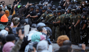 Demonstrators reinforce the barricade to their Gaza solidarity encampment as police storm the University of California, Irvine