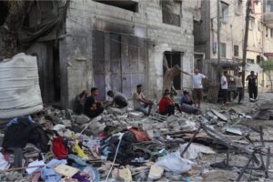 Palestinians outside a house hit by Israeli bombardment in the Tal as-Sultan neighborhood in Rafah