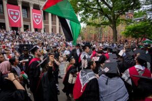 Graduating Harvard students hold Palestinian flags and chant as they walk out in protest over the 13 students who have been barred from graduating due to their antiwar protest activities in Cambridge, Massachusetts, on May 23, 2024