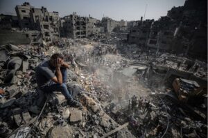 A man sits on debris as Palestinians conduct a search and rescue operation in Jabalya refugee camp in Gaza City, on November 1. 2,000-pound bombs, mostly manufactured by the US, can cause high casualty events and can have a lethal fragmentation radius – an area of exposure to injury or death around the target – of up to 365 meters (about 1,198 feet), or the equivalent of 58 soccer fields in area.