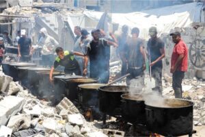 Palestinian cooks with a charity kitchen prepare food among the rubble of houses destroyed during the Israeli military offensive against Khan Younis city in the southern Gaza Strip, on May 30, 2024