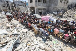 Palestinians eat the food cooked by a charity on Thursday in a destroyed neighborhood in Khan Younis in the southern Gaza Strip