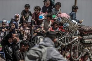 Children sit on a truck as Palestinians with their packed belongings continue to depart from the eastern neighbourhoods of the city due to ongoing Israeli attacks in Rafah, Gaza, on May 8