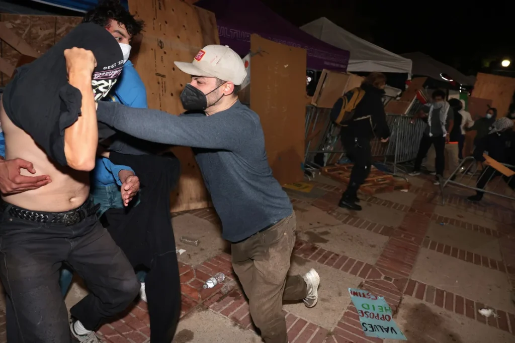 A counterprotester, identified by CNN as Malachi Marlan-Librett, pushes a pro-Palestinian protester in the barrier of the UCLA encampment.