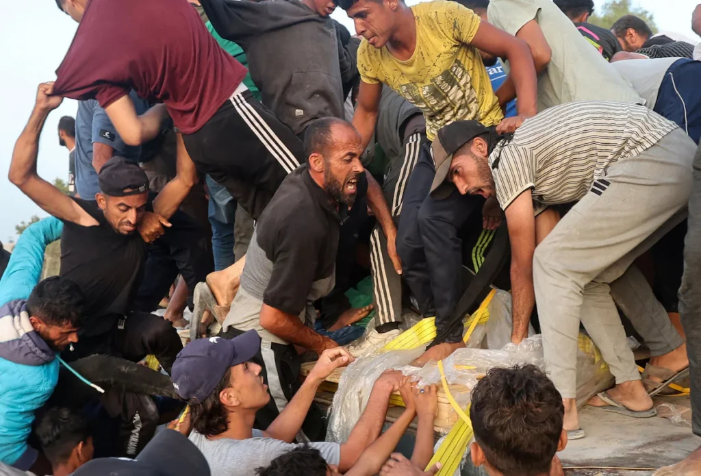 Palestinians climb onto a truck to grab aid that was delivered into Gaza on May 18 via a U.S.-built floating pier.