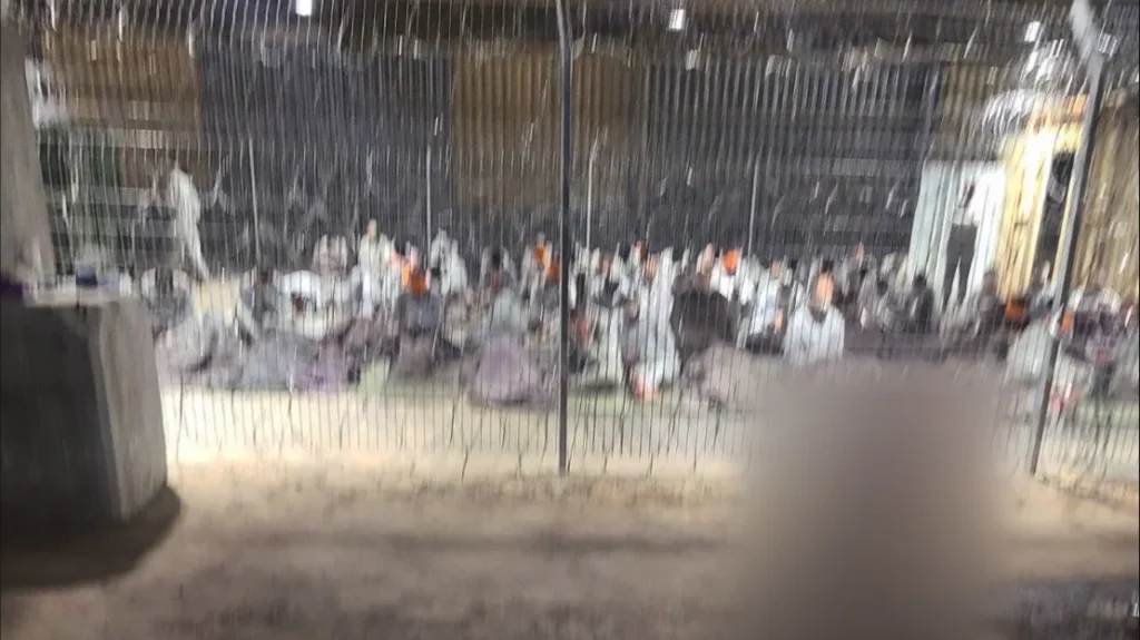 A leaked photograph of an enclosure where detainees in gray tracksuits are seen blindfolded and sitting on paper-thin mattresses. CNN was able to geolocate the hangar in the Sde Teiman facility. A portion of this image has been blurred by CNN to protect the identity of the source. Obtained by CNN