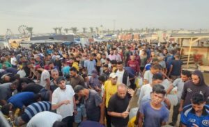 Palestinians gather, waiting for drinking water in one of the IDP camps in Khan Younis.