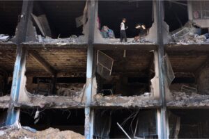 A Palestinians child salvages some belongings from a damaged UN-run school in the Jabalia refugee camp in the northern Gaza Strip on May 31, 2024