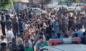 Palestinians pray outside the Al Aqsa Hospital in Deir Al Balah, central Gaza, as airstrike victims are brought for treatment