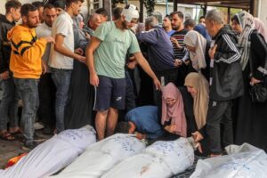 People mourn next to dead bodies of Palestinians, who lost their lives during the Israeli attacks as they take out the bodies from the Al-Najjar Hospital, to perform funeral prayers in Rafah, Gaza on October 17, 2023