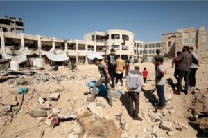 Palestinians inspect the area after an Israeli attack hit the az-Zahra school in the east of Gaza City on August 8 [Anadolu Agency/Dawoud Abo Alkas]