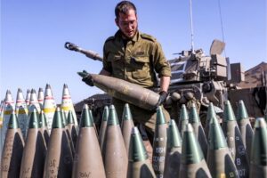 An Israeli soldier carries a 155mm artillery shell near a self-propelled howitzer deployed at a position near the border with Lebanon in the upper Galilee region of northern Israel on October 18, 2023. (Photo: Jalaa Marey/AFP via Getty Images)