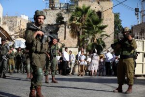 A group of Jewish settlers under the protection of Israeli soldiers raids the Old City area of Hebron, West Bank on August 17, 2024. [Wisam Hashlamoun – Anadolu Agency]