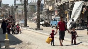 Palestinians carry their belongings as they flee Israeli attacks on the Zeitoun neighbourhood in southern Gaza City on Friday [Hamza Qraiqea/Anadolu]