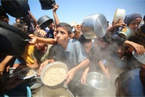 Palestinians wait in line to receive food from charities in Deir el-Balah in central Gaza on August 25, 2024 [Hassan Jedi/Anadolu Agency]