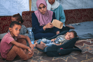 Abdel-Rahman Abu al-Jedian, a displaced Palestinian boy who contracted polio last month, sleeps surrounded by family members in their tent in Deir al-Balah in the central Gaza Strip on Aug. 27, 2024. (Eyad Baba/AFP/Getty Images)