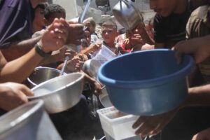 Palestinians in Jabalia Refugee Camp wait in line to receive food distributed by charitable organizations in Jabalia, Gaza on August 1, 2024. [Mahmoud İssa – Anadolu Agency]