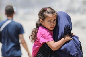 A Palestinian girl clings to her mother in Gaza City, June 2 [Dawoud Abo Alkas/Anadolu]