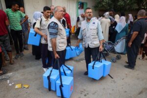 Health workers carry containers filled with polio vaccines in Zawayda, the central Gaza Strip, on Sept. 1, 2024. Photo by Eyad Baba/AFP via Getty Images.