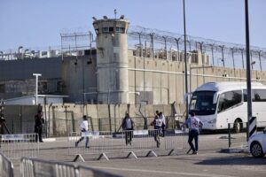 Red Cross officials wait outside Israel’s Ofer Prison as thousands of displaced Palestinians go to check on their homes as the 4-day humanitarian pause begins for prisoner exchange and aid in Ramallah, Gaza on November 24, 2023. [Mostafa Alkharouf – Anadolu Agency]