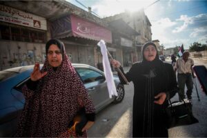 Palestinians raise the white flag as they flee their homes after Israeli forces took them over in Jenin [Nasser Ishtayeh/SOPA Images/LightRocket via Getty Images]