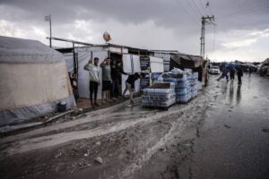 Palestinians, living in makeshift tents in the Al-Mawasi, pose for a photo as people struggle with the strong winds and torrential rains along with Israeli attacks in Khan Yunis, Gaza on September 22 , 2024. [Mahmoud Bassam – Anadolu Agency]