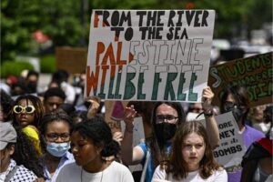 A Pro-Palestinian student holds placard saying ”From river to the sea Palestine will be free” as Pro-Palestinians students, holding banners and Palestinian flags, gather to stage Pro-Palestinian demonstration to show solidarity with Palestinians and demand an immediate ceasefire for Gaza in front of the White House in Washington D.C., United States on May 24, 2024 [Celal Gunes/Anadolu via Getty Images]