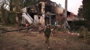 An Israeli soldier walks past a destroyed house in Kibbutz Be’eri, near the border with Gaza, on October 11, 2023. (Photo credit: Menahem Kahana / Getty)