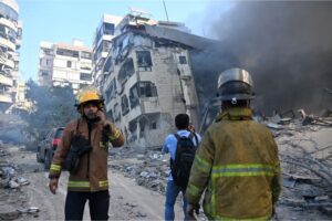 Recsue teams are seen in front of damaged buildings after an Israeli airstrike on Beirut, Lebanon, Thursday