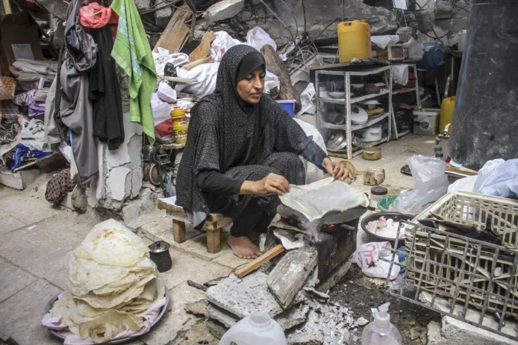 Palestinian woman from the Massoud family, lives in makeshift tents set up on the rubble of their houses destroyed during the Israeli army’s attacks on the Jabalia district of Gaza city, cooks the bread on wood fire among the rubble of their homes in Gaza City, Gaza on September 16, 2024