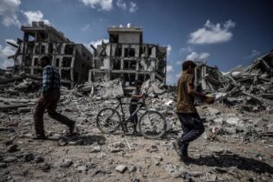 Palestinians retrieve their belongings from among the ruins in the eastern part of Deir al-Balah, Gaza