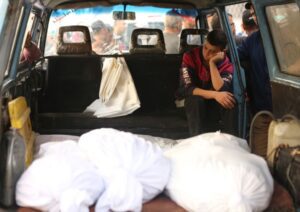 A child sits with the bodies of Palestinians killed in an Israeli attack on the Jabalia al-Baled area on November 10, 2024