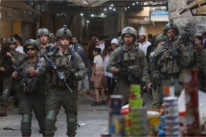 Israeli soldiers accompany Israel settlers through the Old City of Hebron, in the occupied West Bank, on Saturday