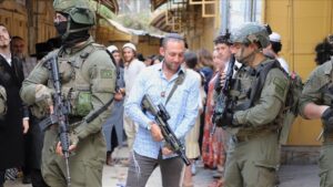 Jewish settlers Israeli security forces amid raid in Hebron, West Bank