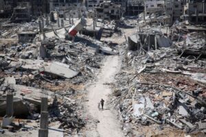 A man pushes a bicycle as he walks amid building rubble near Gaza's Al-Shifa hospital on April 3, 2024.