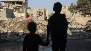 Children stare at the destruction following an Israeli strike in the Nuseirat refugee camp in the central Gaza Strip on 7 November 2024