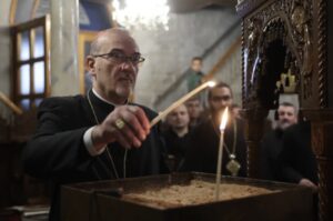 The Latin patriarch of Jerusalem, Cardinal Pierbattista Pizzaballa, lights a candle in the Orthodox Church of St. Porphyrius in Gaza during his visit there on Dec. 22, 2024.