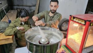 Standing next to a popcorn machine, Israeli soldiers make cotton candy inside an army ‘resort’ for soldiers in north Gaza.