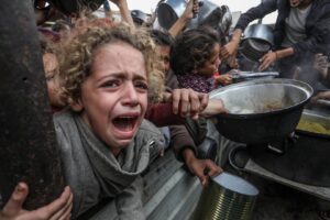 Palestinians including children are frantic with hunger, as they wait to receive food distributed by charitable organizations in Khan Younis, Gaza on November 29, 2024