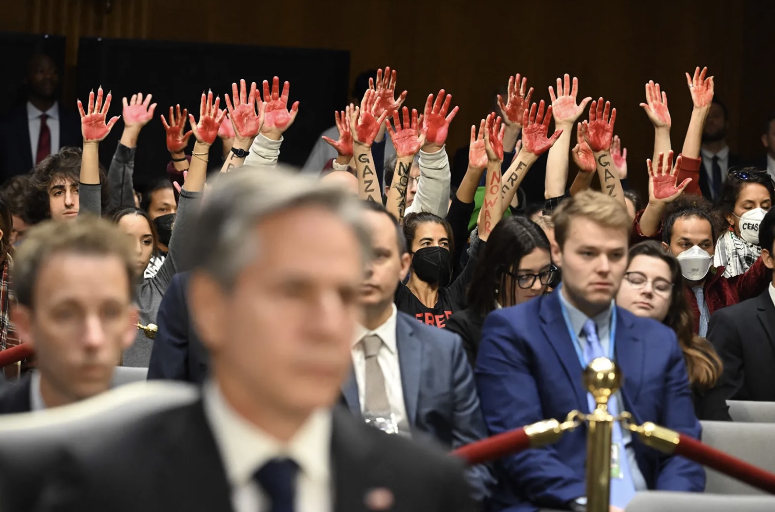 Protesters raise their painted hands as Secretary of State Antony Blinken and Defense Secretary Lloyd Austin testify during a Senate Appropriations Committee hearing on Capitol Hill in Washington, D.C, on Oct. 31, 2023.