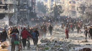 Scores of displaced Palestinians walk along a road in Jabalia, as they leave areas near Gaza City where they had taken refuge